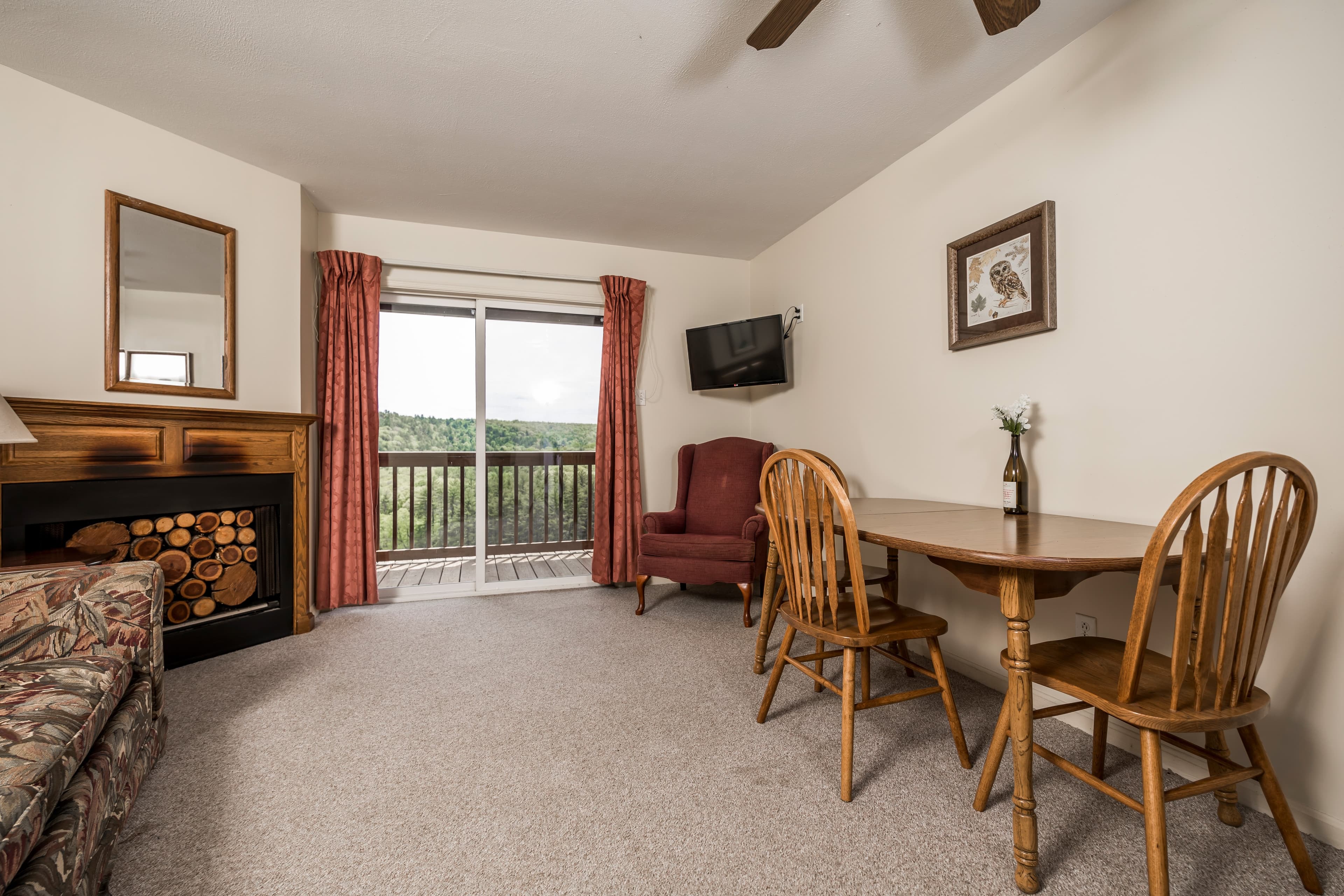 Cozy living area featuring a sofa, dining table, and access to a balcony with mountain views.